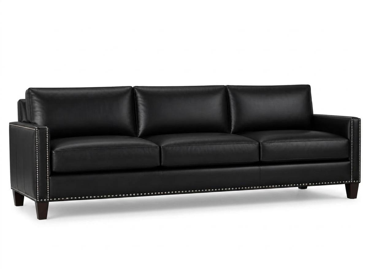 Black leather nailhead sofa on a white studio backdrop